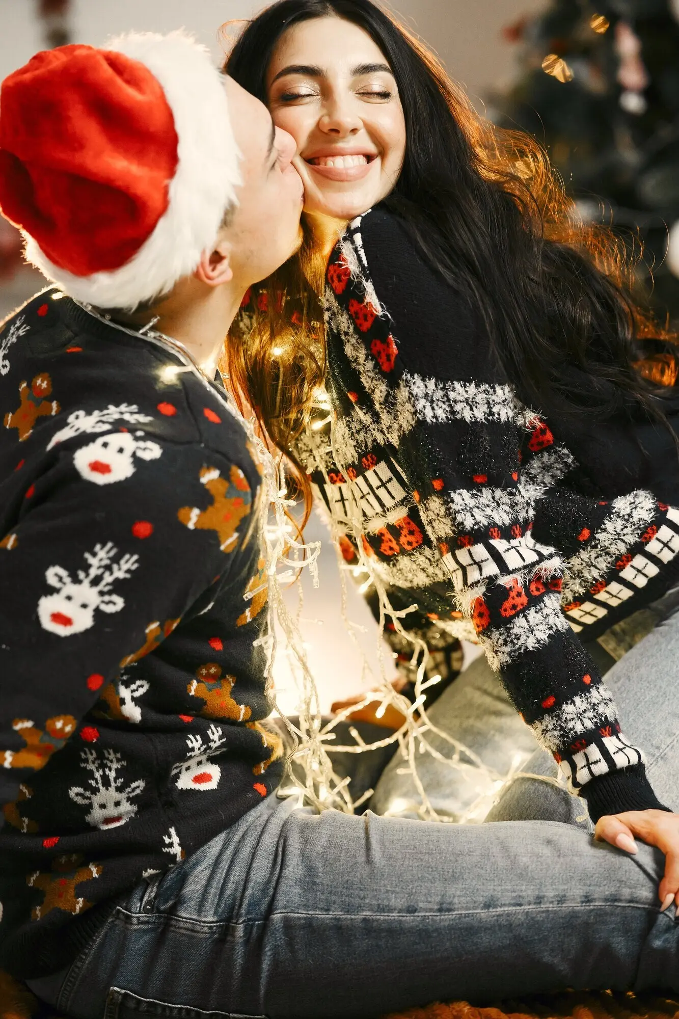 Menschen inmitten von Weihnachtsdekorationen. Mann und Frau in Neujahrspullovern. Familie zu Hause.